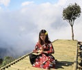 Young Asian woman meditating on the bamboo bridge with clouds on background Royalty Free Stock Photo