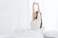 Young Asian woman in the morning she stretching in her bed in the bedroom. Royalty Free Stock Photo