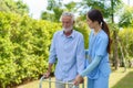 Young Asian woman nurse care giver helping senior old man with mobility walker in garden at home. Senior daycare center, Nurse Royalty Free Stock Photo