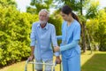 Young Asian woman nurse care giver helping senior old man with mobility walker in garden at home. Senior daycare center, Nurse Royalty Free Stock Photo