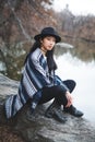 Asian model sitting on a rock staying warm Royalty Free Stock Photo