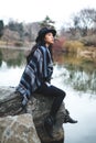 Asian model sitting on a rock staying warm Royalty Free Stock Photo