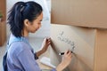 Young Asian Woman Packing Boxes for Moving Out Royalty Free Stock Photo