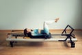 Young asian woman pilates stretching sport in reformer bed instructor girl in a studio Royalty Free Stock Photo