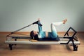 Young asian woman pilates stretching sport in reformer bed instructor girl in a studio Royalty Free Stock Photo