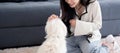 Young asian woman playful with fluffy dog shih tzu for relax with love in the living room at home.