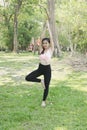 Young asian woman practicing yoga outdoors in morning park. Concept of healthy lifestyle Royalty Free Stock Photo