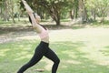 Young asian woman practicing yoga outdoors in morning park. Concept of healthy lifestyle Royalty Free Stock Photo