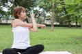 Young asian woman practicing yoga outdoors in public park. healthy lifestyle and relaxation concept Royalty Free Stock Photo