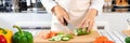 Young Asian woman is preparing healthy food vegetable salad by Cutting cucumber for ingredients on cutting board on light kitchen Royalty Free Stock Photo