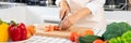 Young Asian woman is preparing healthy food vegetable salad by Cutting tomato for ingredients on cutting board on light kitchen, Royalty Free Stock Photo