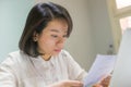 Young Asian woman reading letter document Royalty Free Stock Photo