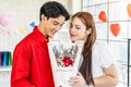 Young asian woman receives a bouquet of red roses as a gift from a man or boyfriend.