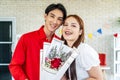 Young asian woman receives a bouquet of red roses as a gift from a man or boyfriend.