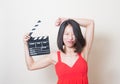 Young asian woman red dress funny face with clapperboard Royalty Free Stock Photo