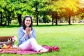Young Asian woman relax time in park.In the morning she is sipping tea , Royalty Free Stock Photo