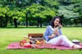 Young Asian woman relax time in park.In the morning she is sipping tea , Royalty Free Stock Photo