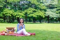 Young Asian woman relax time in park.In the morning she is sipping tea , Royalty Free Stock Photo