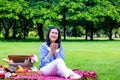 Young Asian woman relax time in park.In the morning she is sipping tea , Royalty Free Stock Photo