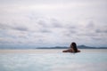 A young woman relaxing in infinity swimming pool looking at a beautiful sea view Royalty Free Stock Photo