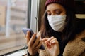 Young Asian Woman In Respirator Mask Using Smartphone In A Train. Ecological Pollution Air Infection Coronavirus Concept Royalty Free Stock Photo