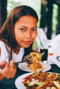 Young Asian woman at the restaurant eating stir fry rice noodle with meat and vegetables, Philippine food call pansit bihon Royalty Free Stock Photo