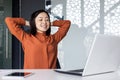 Young Asian woman resting in the office, successfully completed the work, satisfied with the results of the achievement Royalty Free Stock Photo