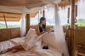 Young asian woman resting and reading a book on the bed in thatched hut among the mountain on vacation Royalty Free Stock Photo