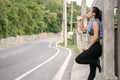 Young Asian woman runner resting after workout running and drinking water in street road. Royalty Free Stock Photo