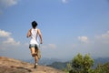 Young asian woman runner running on mountain rock peak Royalty Free Stock Photo