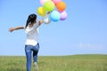 Young asian woman running with colored balloons Royalty Free Stock Photo