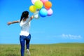 Young asian woman running with colored balloons Royalty Free Stock Photo