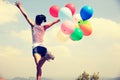 Young asian woman running with colored balloons Royalty Free Stock Photo