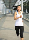 Young asian woman running at modern city footbridg Royalty Free Stock Photo