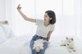 Young Asian women selfie with mobile phone. Young Asian women and girl were in bed with a dog. Girl and white Hokkaido inu dog and Royalty Free Stock Photo