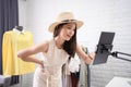 Young Asian woman selling clothes online, she is chatting and checking orders on her laptop Royalty Free Stock Photo