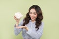 Young asian woman shaking out empty piggy bank on green background. Royalty Free Stock Photo