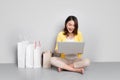 Young asian woman shopping online at home sitting besides row of shopping bags Royalty Free Stock Photo