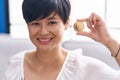 Young asian woman with short hair holding tron cryptocurrency coin looking positive and happy standing and smiling with a Royalty Free Stock Photo