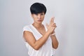 Young asian woman with short hair standing over isolated background holding symbolic gun with hand gesture, playing killing