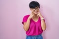 Young asian woman with short hair standing over pink background smiling with open mouth, fingers pointing and forcing cheerful Royalty Free Stock Photo