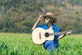 Women short hair wear hat and sunglasses sit playing guitar in g Royalty Free Stock Photo