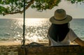 Young Asian woman sit and relax on swings at seaside on summer vacation. Summer vibes. Woman travel alone on holiday. Backpacker