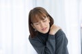 Young Asian woman sitting on bed has neck pain after wake up in the morning Royalty Free Stock Photo