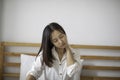 young Asian woman sitting on bed has neck pain Royalty Free Stock Photo