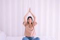 Young asian woman sitting on bed practicing doing yoga meditation,Workout exercise after waking up in morning,Healthy and lifestyl Royalty Free Stock Photo