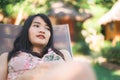 Young Asian woman sitting on bench relax on beach, Beautiful female happy relax near sea. Lifestyle women travel on beach concept Royalty Free Stock Photo