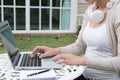 Young asian woman sitting on chair with headphone using laptop. Royalty Free Stock Photo