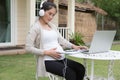 Young asian woman sitting on chair listening to music and using Royalty Free Stock Photo