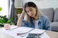 Young Asian woman sitting expression face stressed by calculate expense on table from invoice or bill Royalty Free Stock Photo